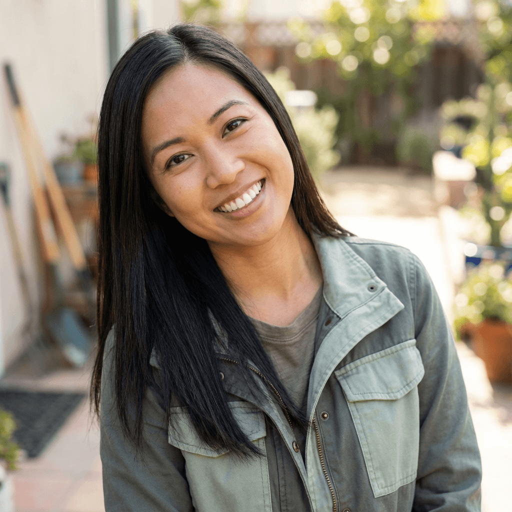 Female cat owner in her early 30s, East Asian, smiling warmly at veterinary clinic